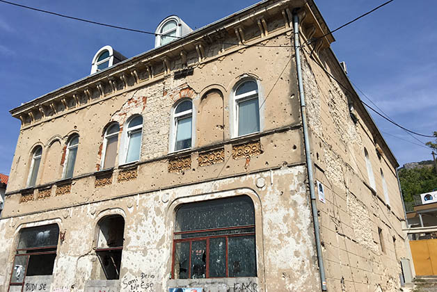 Edificio lleno de hoyos de las balas. Así encontramos muchos. Foto © Silvia Lucero